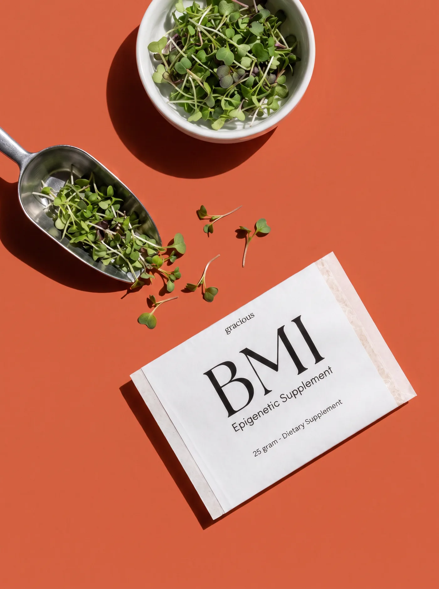 A BMI sachet beside a scoop of freshly grown microgreens on coral